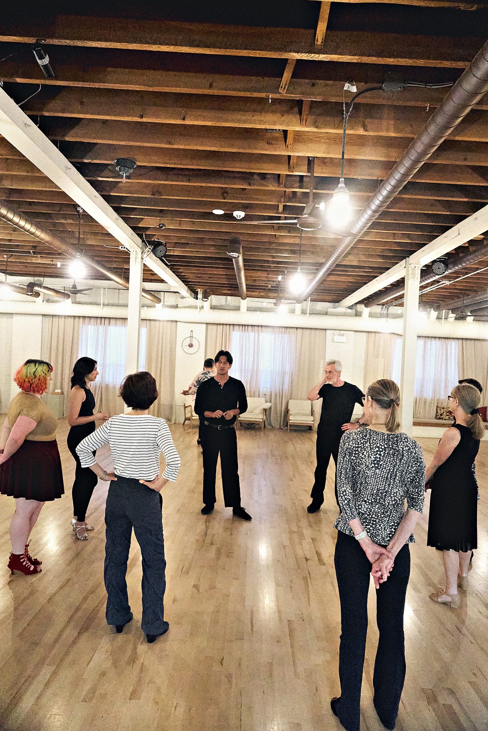 Students rotating partners during a group dance class at Beach Ballroom in Toronto
