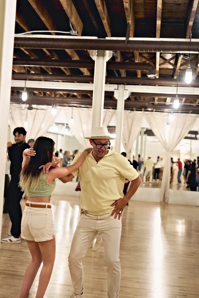 Group of adults dancing together at a Latin social night at Beach Ballroom in Toronto